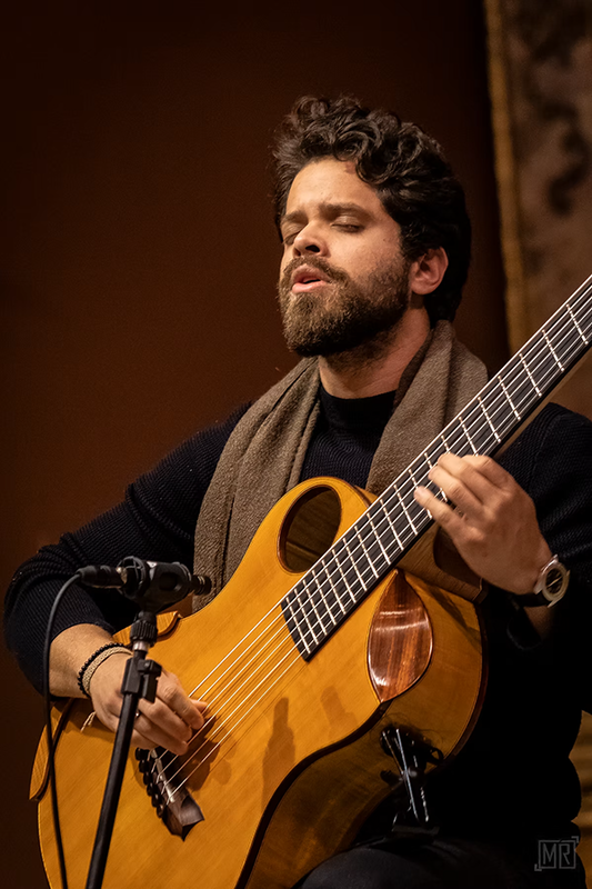 Filipe Moreno spielt mit geschlossenen Augen einen sechssaitigen akustischen Bass.
